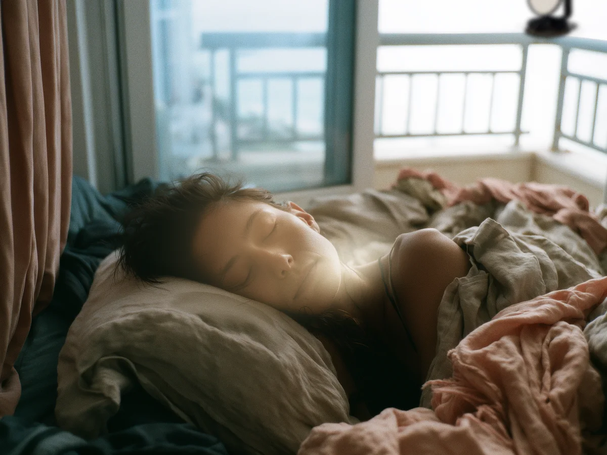Schlafende Frau im Bett, warmes Morgenlicht vom ohoya Heliostat auf ihrem Gesicht